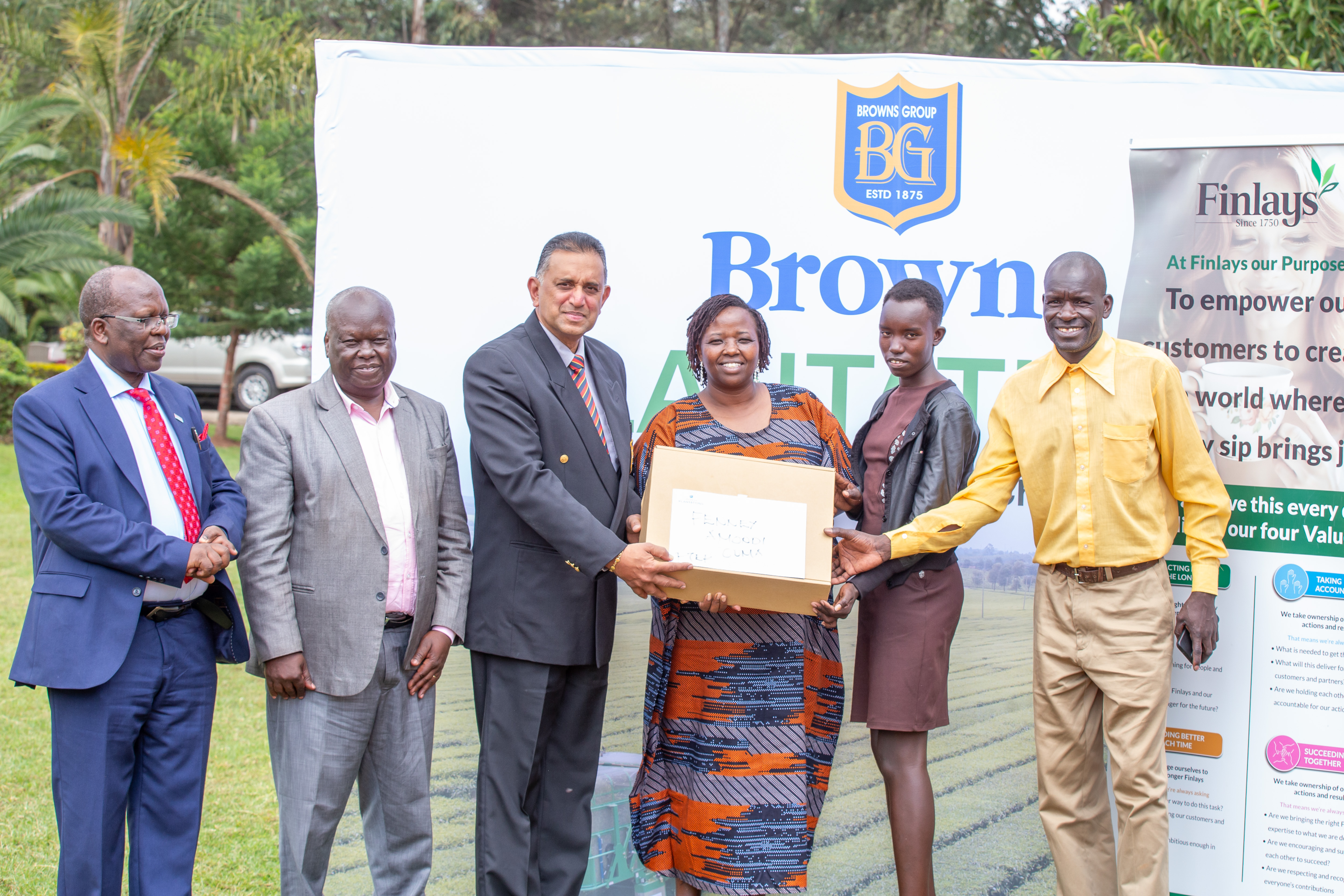 Browns Plantation CEO Mr. Dushanth Ratwatte presents a Scholarship award letter and a laptop to one of the beneficiaries during the unveiling of scholarship beneficiaries at Fair Hills Hotel in Bomet. Photo/Kimagata Marindany
